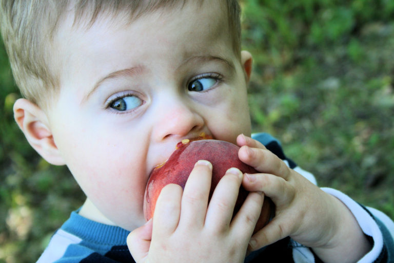 boy eating peach.